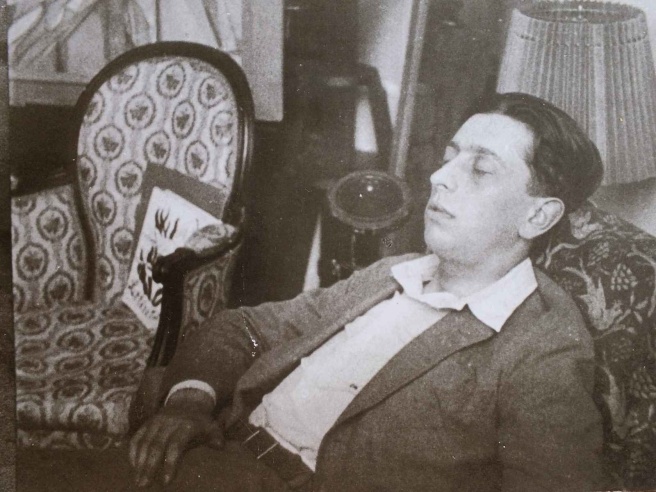 A photo of a man sleeping in a chair with his eyes closed.